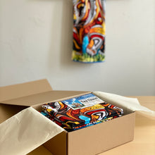 Load image into Gallery viewer, Colorful towel with abstract design on a brown surface