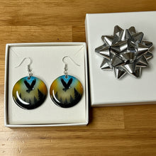 Load image into Gallery viewer, Pair of earrings with nature-themed design in a box on a beige surface