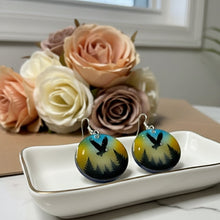 Load image into Gallery viewer, Pair of earrings with nature design on a white plate with flowers in the background