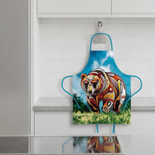 Load image into Gallery viewer, Apron with a colorful bear design against a blue sky and green grass background