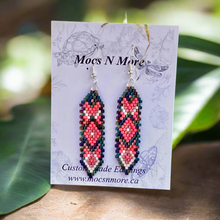 Load image into Gallery viewer, Beaded earrings on a Mocs N More branded card with green leaves in the background