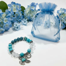 Load image into Gallery viewer, Beaded bracelet with turquoise and clear beads on a textured beige surface