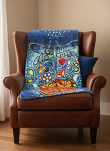 Load image into Gallery viewer, Decorative blanket with a dragonfly design on a brown armchair.