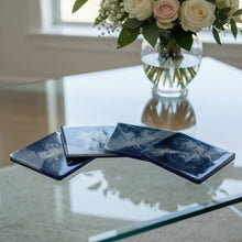 Load image into Gallery viewer, Four dark blue coasters with star patterns on a wooden surface
