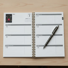 Load image into Gallery viewer, Planner with monthly layout on a concrete surface