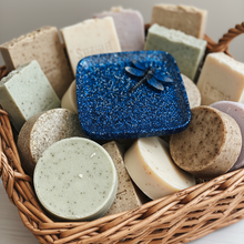 Load image into Gallery viewer, Basket of various soap bars with a blue glittery container.