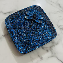 Load image into Gallery viewer, Blue glittery square object with a dragonfly on a beige surface