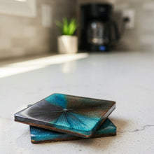 Load image into Gallery viewer, Two glass coasters with a gradient design on a wooden surface.