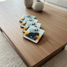 Load image into Gallery viewer, Set of four coasters with bear design on a wooden surface