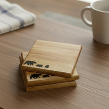 Load image into Gallery viewer, Wooden coasters with bear design on a wooden surface