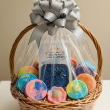 Load image into Gallery viewer, Gift basket with colorful bath bombs and a bottle of bubble bath, wrapped with cellophane and a silver bow.