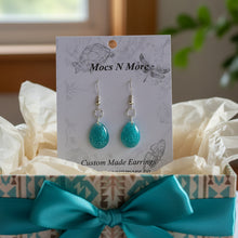 Load image into Gallery viewer, Turquoise glitter teardrop earrings on a 'Mocs N More' branded card.