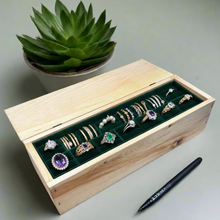 Load image into Gallery viewer, Wooden box with green interior holding various rings, next to a pen and a potted plant on a light gray surface.