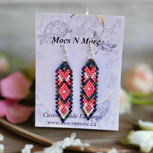 Load image into Gallery viewer, Beaded earrings on a Mocs N More branded card with flowers in the background