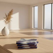 Load image into Gallery viewer, Set of blue and white coasters on a beige surface