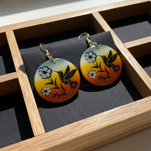 Load image into Gallery viewer, Pair of earrings with floral and bird design on a wooden surface