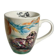 Load image into Gallery viewer, A white ceramic coffee mug with a colorful hand-painted design of a cat and a feather, displayed on a white shelf.