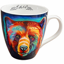 Load image into Gallery viewer, A white ceramic coffee mug featuring a colorful, stylized bear face illustration on the side, set against a brown background.