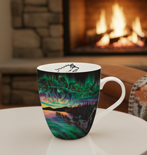 Load image into Gallery viewer, Colorful mug on a small table in front of a fireplace with a cozy blanket draped over a chair.