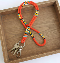 Load image into Gallery viewer, Neon orange lanyard with colorful pattern and metal clip on a white background