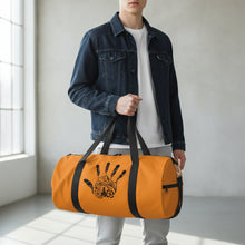 Load image into Gallery viewer, Orange duffel bag with black handprint design on a white background