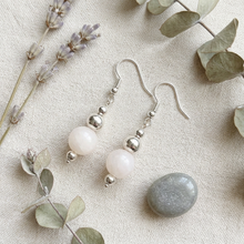 Load image into Gallery viewer, Flat-lay lifestyle photo of the earrings on linen