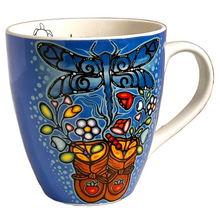 Load image into Gallery viewer, A blue ceramic coffee mug featuring a hand-painted folk art design of a dragonfly, flowers, and a pair of orange work boots with small red strawberry details, shown on a plain white background.