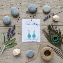 Load image into Gallery viewer, Light turquoise sparkle teardrop earrings flat lay composition