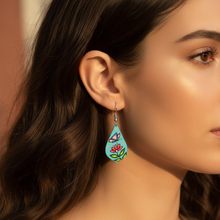 Load image into Gallery viewer, Model wearing teal teardrop Indigenous art earrings with butterfly and flower design