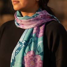 Load image into Gallery viewer, Close-up of the Hummingbird signature scarf draped around a woman's neck, showing vibrant teal and pink art detail