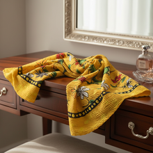 Load image into Gallery viewer, Yellow patterned blanket draped over a wooden desk with a mirror and perfume bottle in the background.