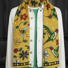Load image into Gallery viewer, Mannequin wearing a colorful patterned yellow scarf with floral and bird designs.